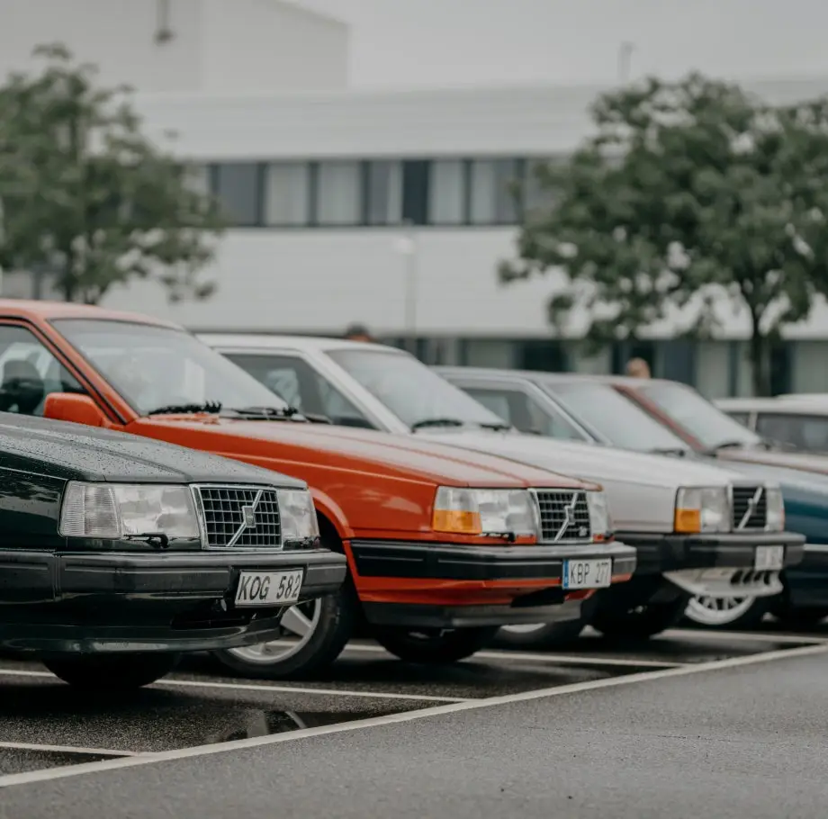 Reihe klassischer Volvo-Fahrzeuge auf einem Parkplatz
